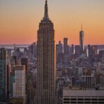 Vue aérienne de Manhattan au crépuscule, avec l'Empire State Building et One World Trade Center