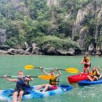 Deux kayaks pagayent entre les pitons karstiques de la baie d'Ha Long