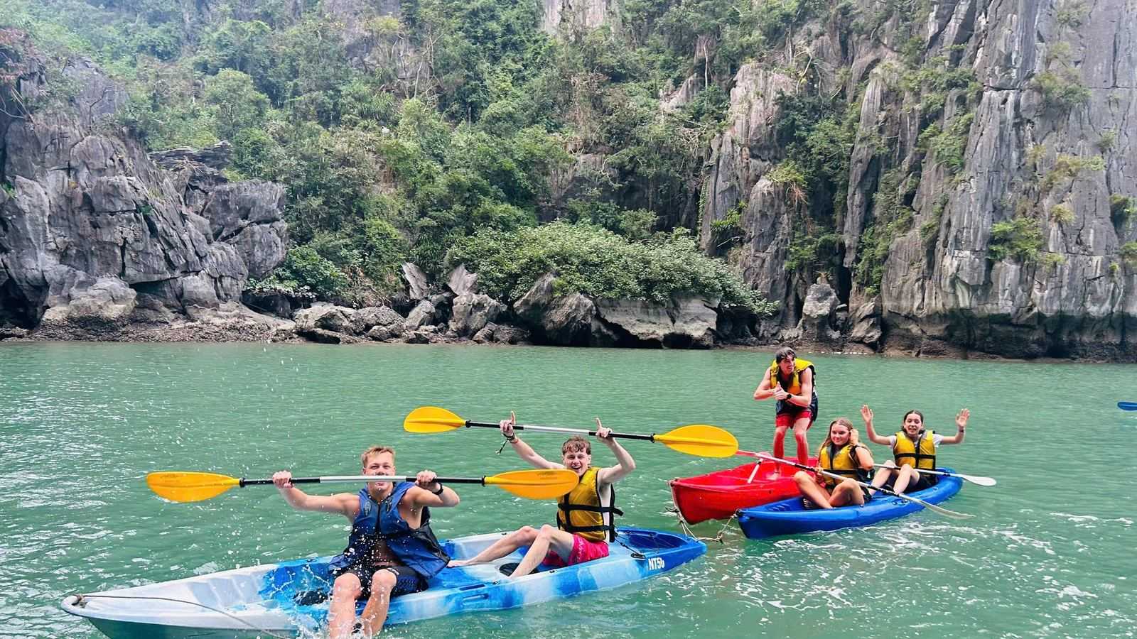 Deux kayaks pagayent entre les pitons karstiques de la baie d'Ha Long