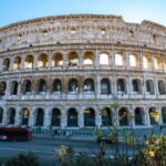 La façade extérieure du Colisée de Rome, ses quatre niveaux d'arcades sous un ciel dégagé